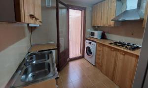 a kitchen with a sink and a washing machine at El Rincon de Camarena in Camarena de la Sierra +2 photos