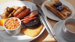 un plato de desayuno con frijoles y tostadas en Pantile Lodge, en Milfield