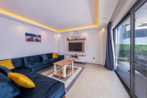 Una sala de estar con un sofá azul y un televisor. en Villa Lovelet, en Kas