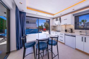 cocina con encimera blanca y sillas azules en Villa Lovelet, en Kas