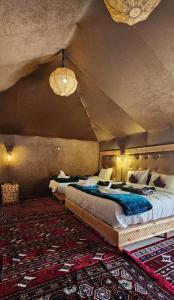a bedroom with two beds in a room at fabulousluxurycamp in Merzouga