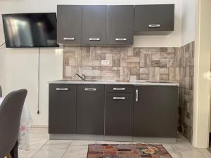 a kitchen with black cabinets and a sink at Univerzum in Šibenik +7 photos