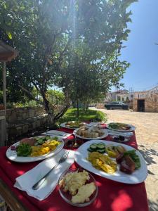 a table with plates of food on a red table cloth at Vila Bleta in Vlorë