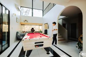 a man standing in a room with a pool table at Cosy Pool Villa Khaoyai in Nong Nam Daeng