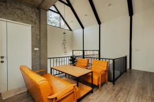 a room with orange chairs and a table and a window at Cosy Pool Villa Khaoyai in Nong Nam Daeng