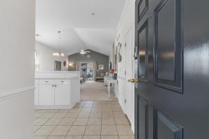 a kitchen with white cabinets and a door at Stylish Barefoot Golf Condo with Pool Access in North Myrtle Beach +34 photos