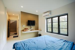 a bedroom with a blue bed and a window at Cosy Pool Villa Khaoyai in Nong Nam Daeng +25 photos