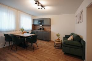 a living room with a table and a couch and a kitchen at Be Grand Apartments Rust in Rust