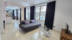 a living room with a couch and a table at Felix Saenz Boutiques Suites by Del Parque Flats in Málaga