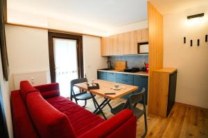 a living room with a red couch and a table at LAB House in Madonna di Campiglio