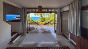 Habitación con una gran puerta corredera de cristal con vistas al océano. en Villa Giulia Morro, en Morro de São Paulo