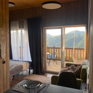 een woonkamer met uitzicht op een balkon bij Magic Place-Чарівне місце in Verkhovyna