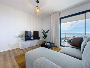 a living room with a couch and a flat screen tv at Atlantic Haven by Atlantic Holiday in Garajau