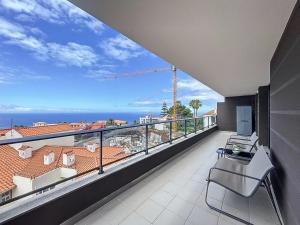 a balcony with chairs and a view of the ocean at Atlantic Haven by Atlantic Holiday in Garajau