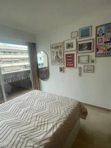 a bedroom with a bed with a window and pictures on the wall at Appartement à vence in Vence