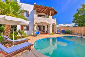 une maison dotée d'une piscine avec des chaises et un parasol dans l'établissement Villa Yasemin, à Kaş