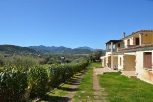 a row of trees in front of a house at FTA-BEL01apt 6 pax vicino al mare in Tanaunella
