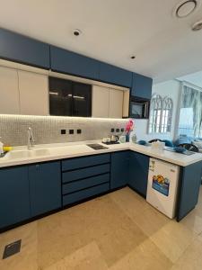 a kitchen with blue cabinets and a sink at برج داماك الكورنيش الجناح اليوناني Damac jeddah Tower in Jeddah