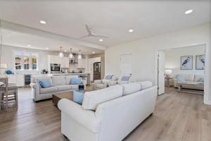 a living room with white furniture and a kitchen at Large Family Retreat Near Beach Private Decks in Wells