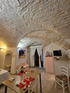un salon avec un plafond en pierre et une table dans l'établissement Il Papavero, à Martina Franca