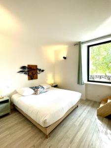 a bedroom with a bed and a large window at La tanière d'Agoult in Goult
