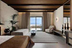 a bedroom with two beds and a view of the ocean at Maximus Mykonos in Platis Gialos +103 photos