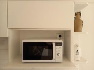un horno microondas blanco en una cocina blanca en Cabrera Apart, en Buenos Aires