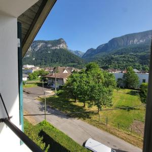 a view from the window of a house with mountains at Au bord du Foron in Scionzier