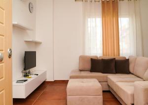a living room with a couch and a tv at Kapri Apartaments Qerret in Qerret +66 photos