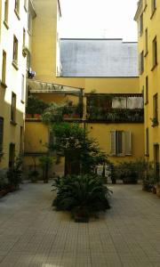 un edificio con un cortile con piante di Le Comari a Milano