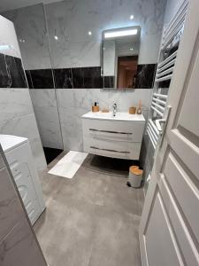a white bathroom with a sink and a mirror at vacance de rêve in Cavalaire-sur-Mer