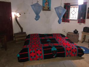 a bedroom with a bed with a red and black blanket at Tiko Community Centre in Saint Francis +47 photos