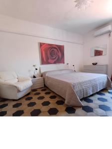 a bedroom with a bed and a chair and a painting at Centrale appartamento Via Roma in Follonica