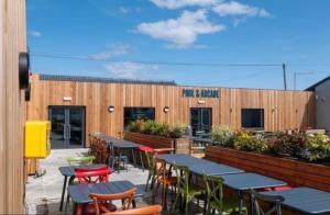a restaurant with tables and chairs in front of a building at Biggerstaffs retreat in Lossiemouth