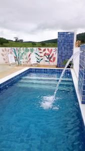 a swimming pool with a water fountain at Vila Negreiros Serra Negra Casa 4 in Bezerros