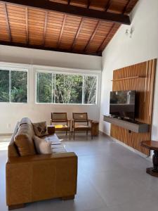 a living room with a couch and a tv at Pousada Lambari Montanha Hotel in Lambari