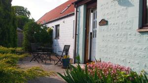 een patio met een tafel en stoelen naast een gebouw bij Pantile Lodge in Milfield