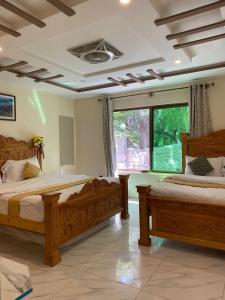 una camera da letto con due letti e una finestra di Arcadian Resort Skardu a Skardu