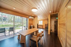 a dining room with a wooden table and chairs at Re to Li - りとり - 一棟貸しの宿 in Tsumagoi