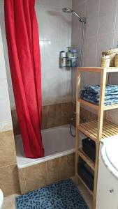 eine Dusche mit einem roten Vorhang im Bad in der Unterkunft ENCANTADOR apartamento frente a la playa de Bara in Roda de Berà + 67 Fotos