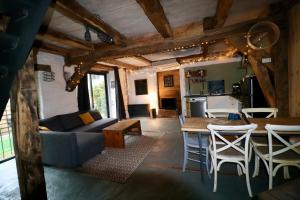 a living room with a couch and a table at La grange de Louise in La Chapelle-Taillefert