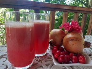 two glasses of juice and fruit on a table at The Pool House in Saint Philip