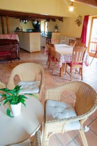 a dining room with tables and chairs and a kitchen at Le Berghon in Fontan
