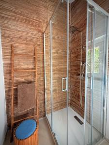 a bathroom with a shower with a wooden wall at Maison Sud entre mer et vignes in Saint-Julien les Martigues