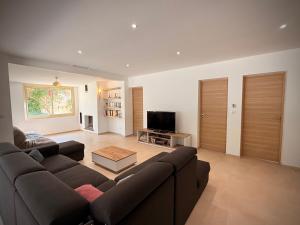 a living room with a couch and a tv at Maison Sud entre mer et vignes in Saint-Julien les Martigues