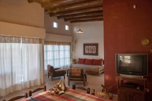 a living room with a couch and a television at Finca Silvestre in San Rafael