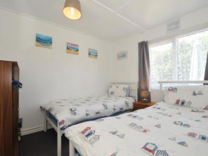 a bedroom with two beds and a window at 13 Hillside in Bude