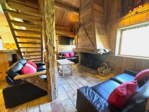 a living room with couches and a staircase in a cabin at Chalet de charme 14 pers. au pied des pistes avec parking, sauna et wifi - FR-1-452-108 in Les Menuires