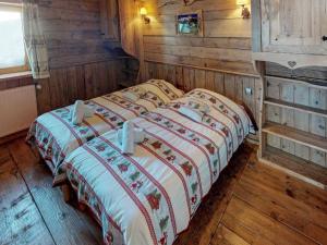 a large bed in a room with wooden walls at Chalet de charme 14 pers. au pied des pistes avec parking, sauna et wifi - FR-1-452-108 in Les Menuires