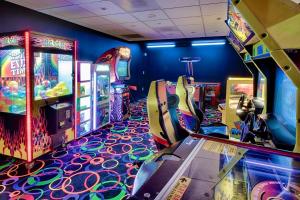 ein Raum mit vielen Arcade-Spielen und einer Spielkonsole in der Unterkunft Wyndham National Harbor 4BR Apartment with Resort Access in Oxon Hill